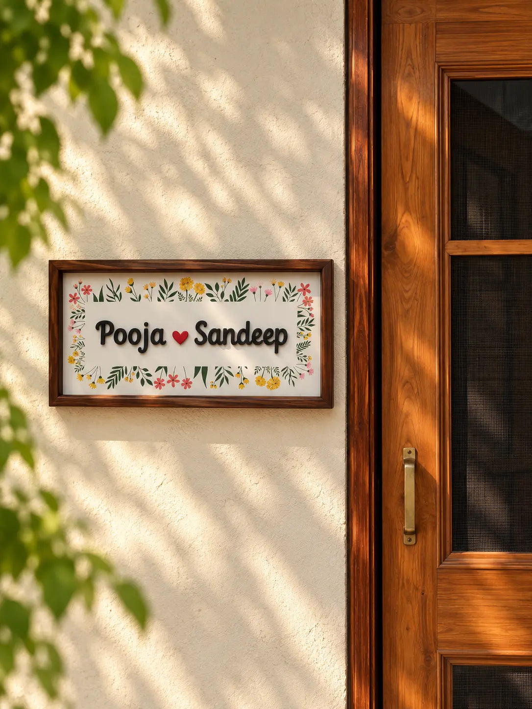 White wildflower border name plate with raised 3D lettering in a wooden frame beside a wooden door